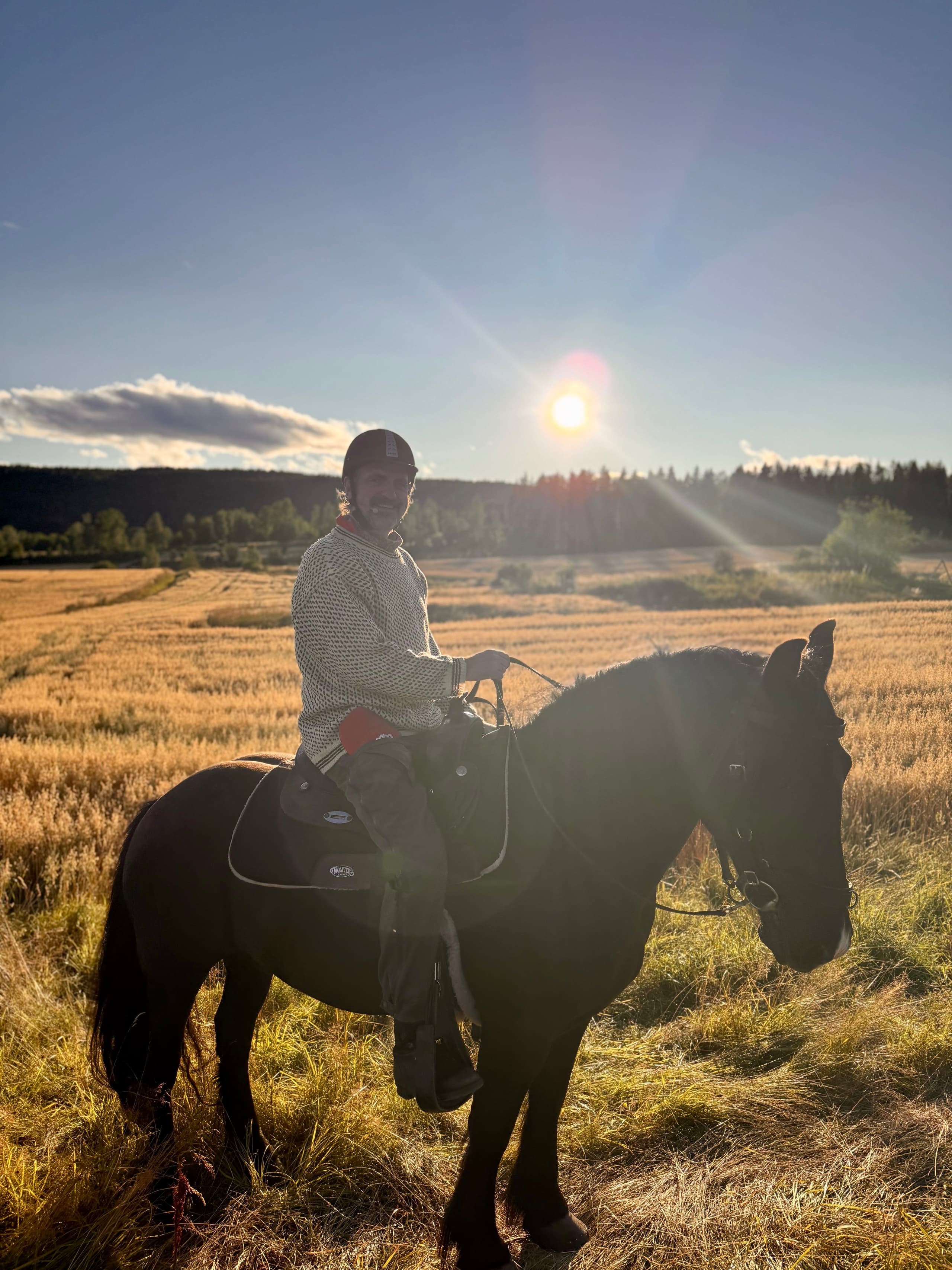 Person på hest i solnedgang over Maridalen